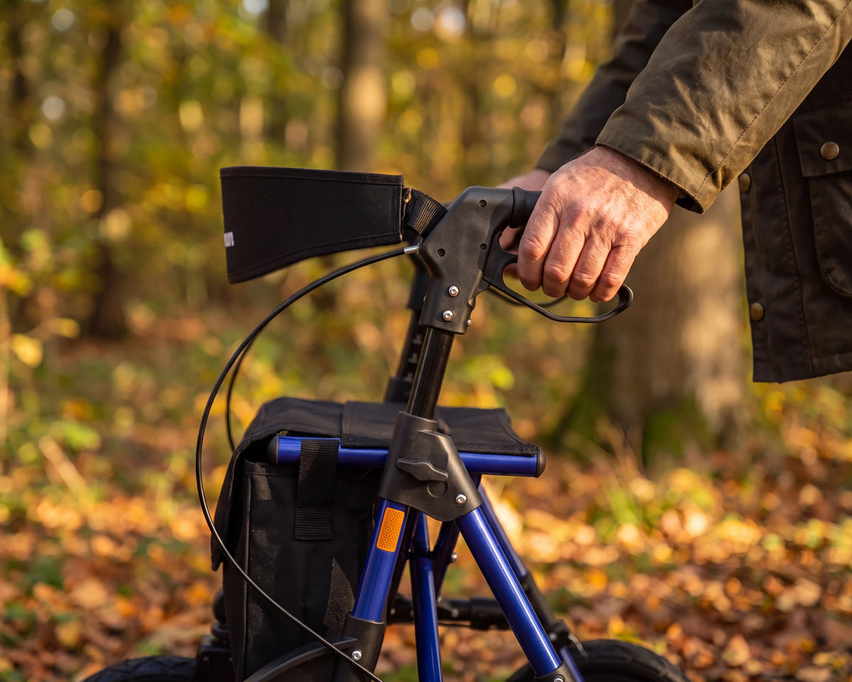 A hand on the handle and brake lever of the Parvum Rebel in blue in an autumn forest.