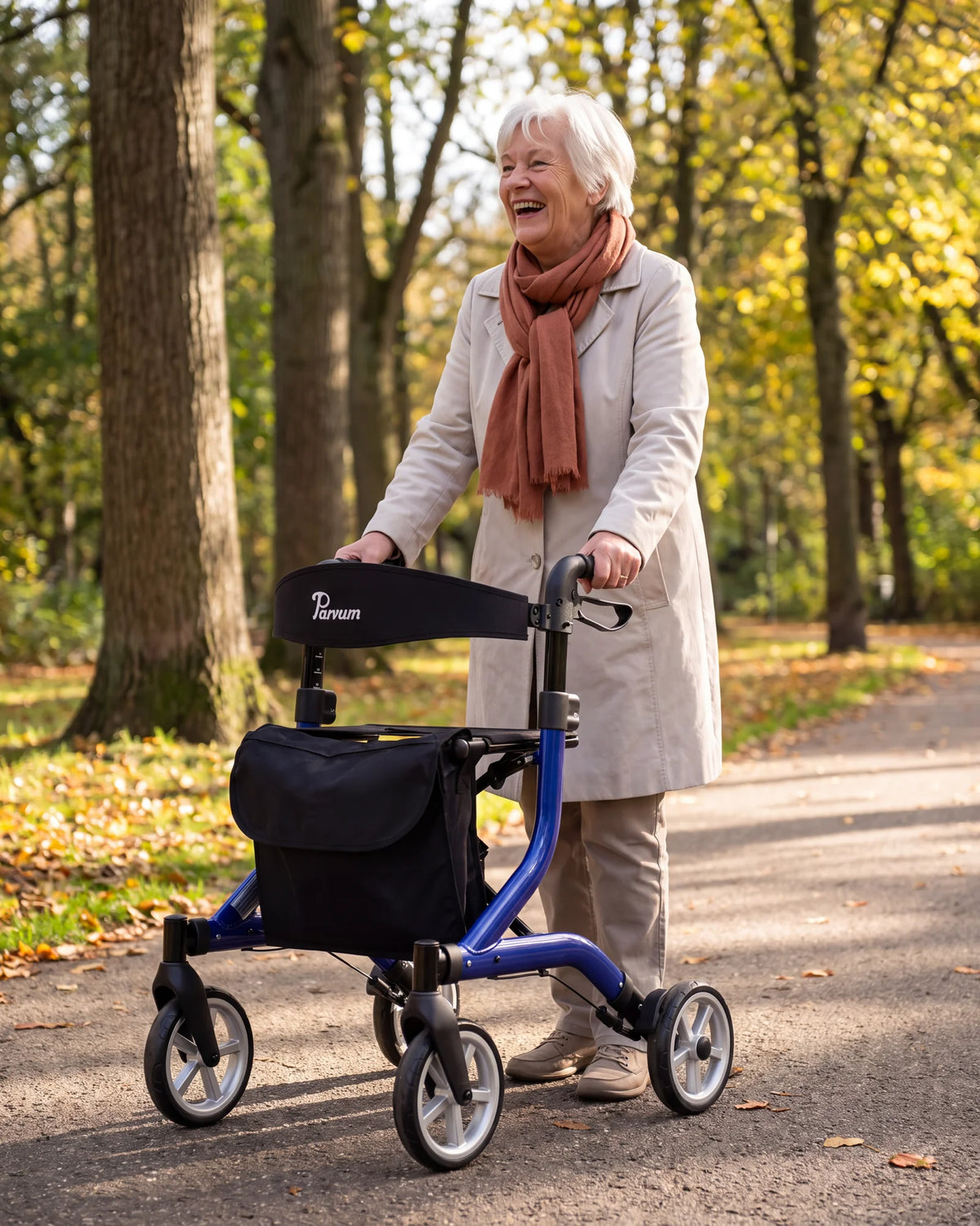 Parvum SuperLight in blue under tall trees in a park; a woman with white hair laughs, her hands on the handles.