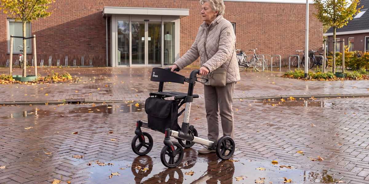 Parvum Riva in gray in front of the entrance of a community center after a rain shower; a woman stops for a moment.